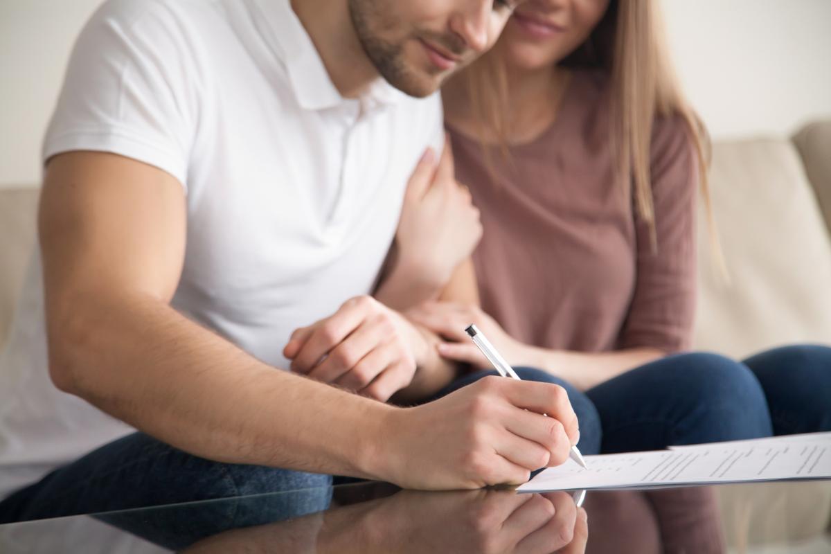 Couple signing prenuptial agreement